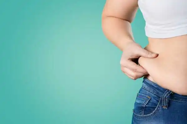 Image of woman pinching her love handles to show weight gain Iver