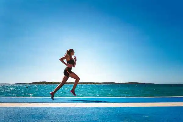 Woman running showing strong leg muscle Iver